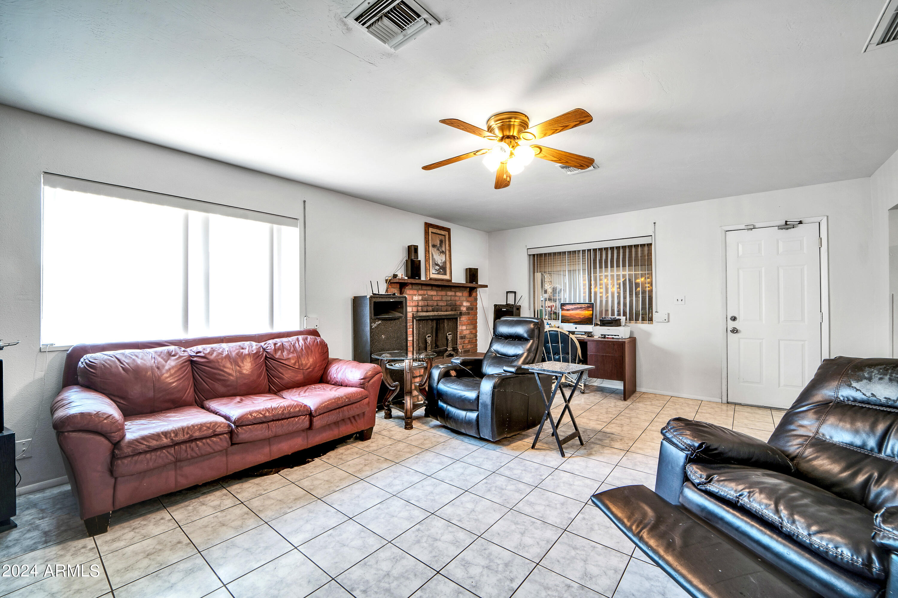 7601 West Osborn Road Phoenix, AZ 85033 - Photo 9 of 37 a living room with furniture a ceiling fan and a window