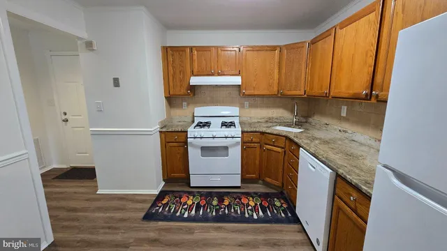 a kitchen with granite countertop a sink stove and cabinets