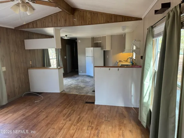 a view of a hallway with wooden floor and a cabinet