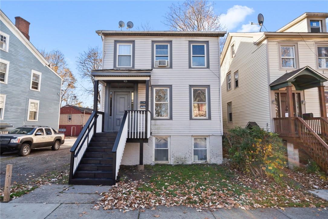 a view of a brick building with many windows and plants