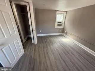 an empty room with wooden floor and entrance