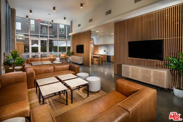 a living room with furniture a flat screen tv and a large window