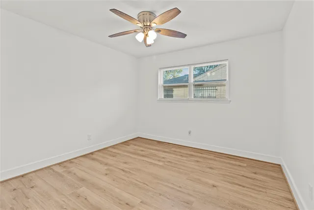 an empty room with wooden floor and window