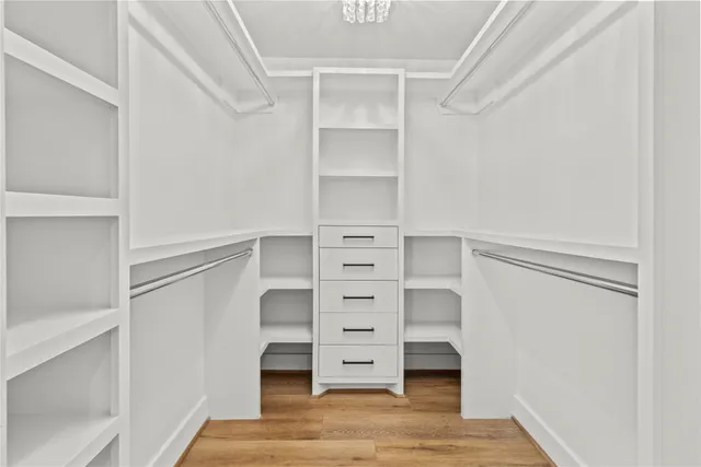a view of walk in closet with empty racks