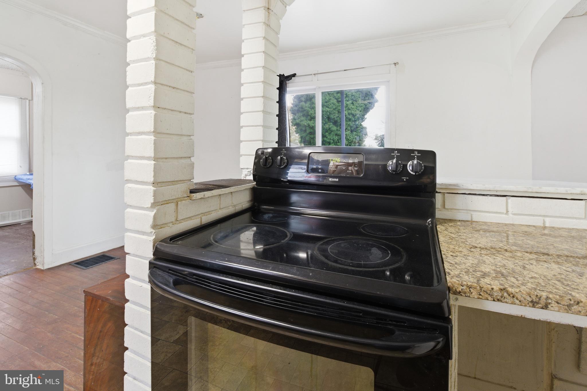 6408 Eastbourne Avenue Baltimore, MD 21224 - Photo 12 of 34 a kitchen with a stove and a microwave