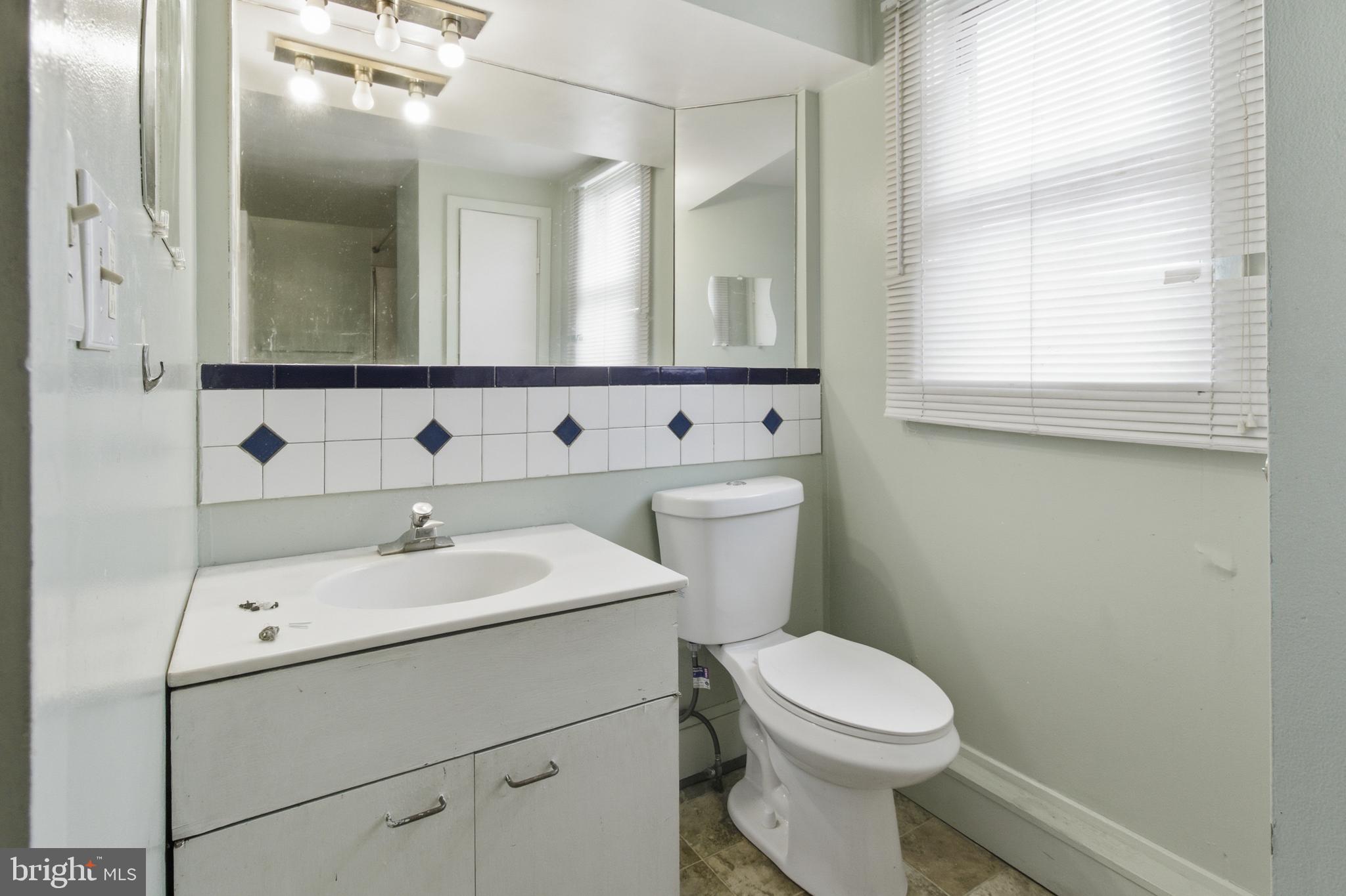 6408 Eastbourne Avenue Baltimore, MD 21224 - Photo 22 of 34 a bathroom with a toilet sink and mirror