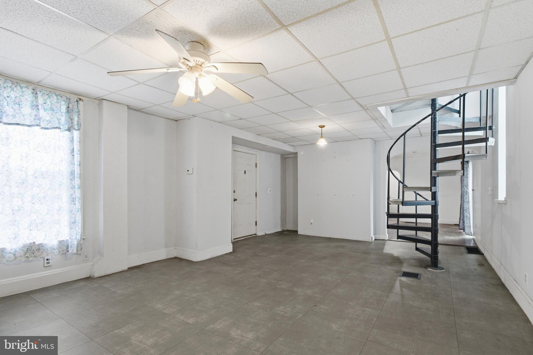 6408 Eastbourne Avenue Baltimore, MD 21224 - Photo 5 of 34 en empty room with windows and ceiling fan