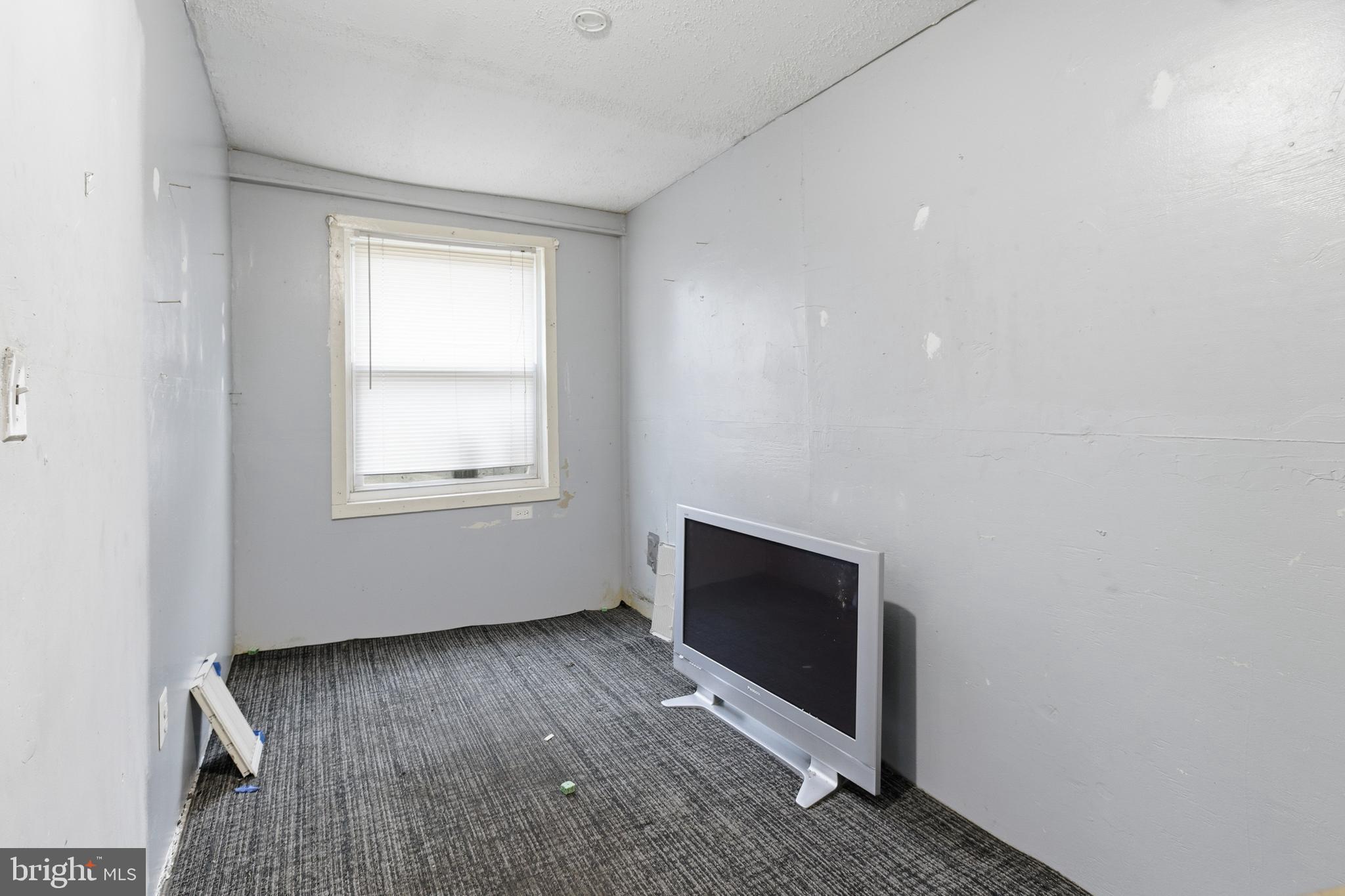 6408 Eastbourne Avenue Baltimore, MD 21224 - Photo 6 of 34 a view of an empty room with wooden floor and a window