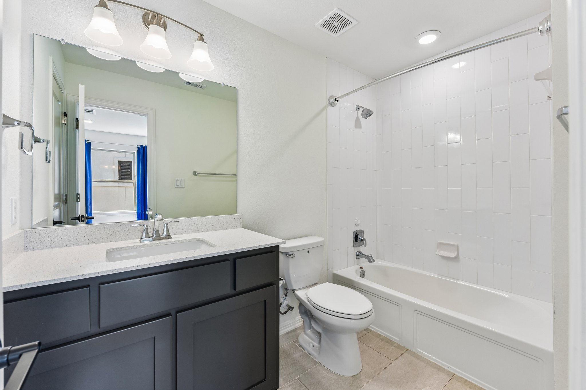 19113 Freeman Circle Austin, TX 78738 - Photo 21 of 37 A well-appointed bath features a sleek vanity, tiled flooring, and a classic tub with an integrated shower.