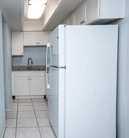 a kitchen with granite countertop white cabinets and white appliances