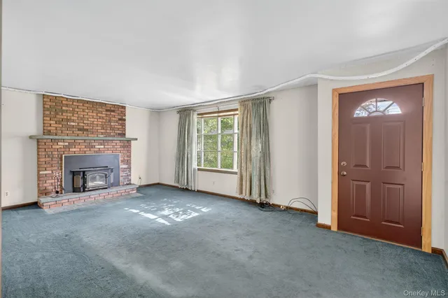 an empty room with windows fireplace and a sink