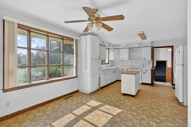 a living room with stainless steel appliances furniture a rug and a large window