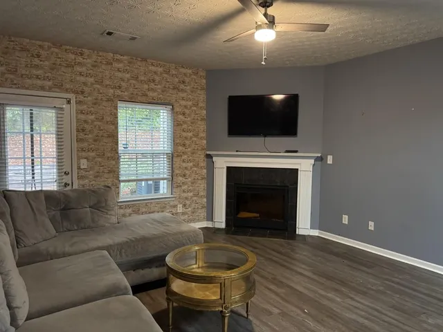 a living room with furniture a flat screen tv and a fireplace