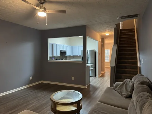 a living room with furniture and a wooden floor