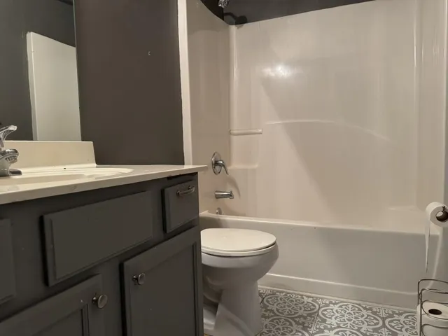 a bathroom with a sink a toilet a mirror and shower