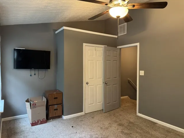 a room with wooden floor and ceiling fan