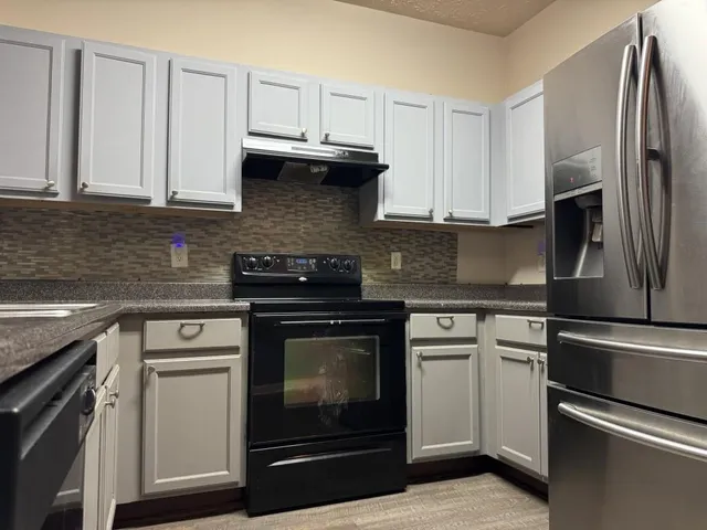 a kitchen with cabinets stainless steel appliances and a sink