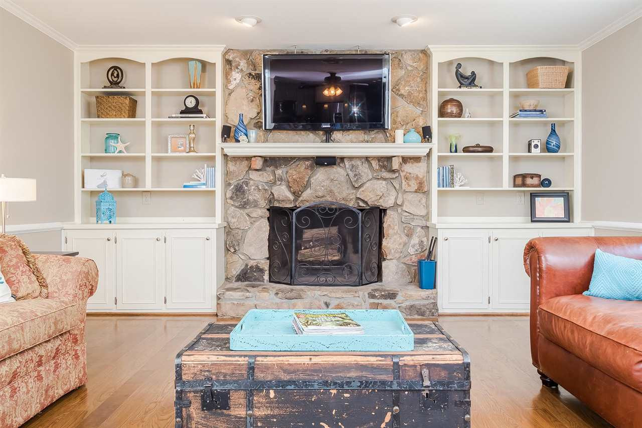 5213 Caber Road Raleigh, NC 27613 - Photo 10 of 25 Built ins flank the stone fireplace