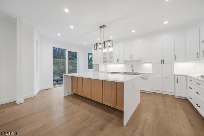 85 Pine Brook Road Montville, NJ 07082 - Photo 14 of 50 a kitchen with kitchen island granite countertop a sink cabinets and wooden floor
