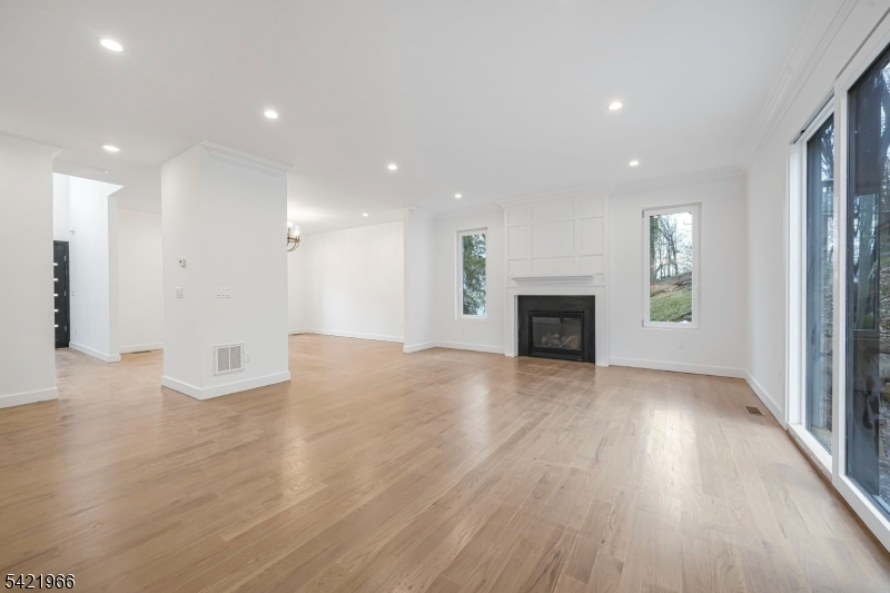 85 Pine Brook Road Montville, NJ 07082 - Photo 22 of 50 an empty room with wooden floor and a fireplace