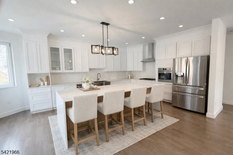 85 Pine Brook Road Montville, NJ 07082 - Photo 7 of 50 a kitchen with stainless steel appliances kitchen island granite countertop a refrigerator a stove a sink a dining table and chairs with wooden floor