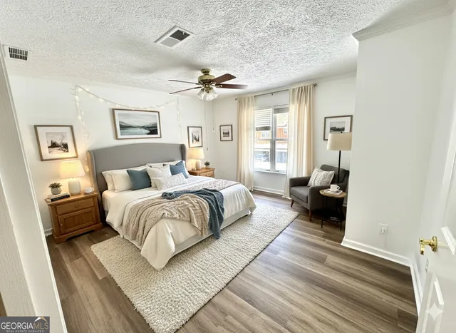 a large bedroom with a bed and wooden floor