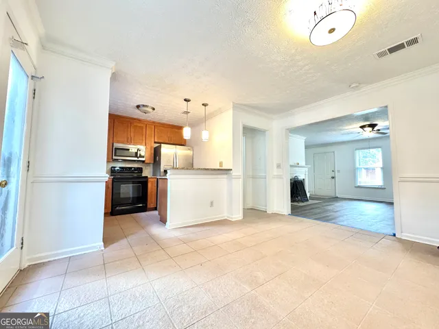 a view of open kitchen with a sink refrigerator and window