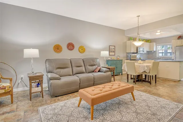 a living room with furniture a chandelier and a flat screen tv