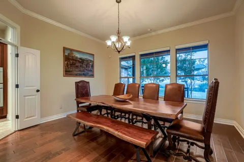 a view of a dining room with furniture a chandelier and wooden floor