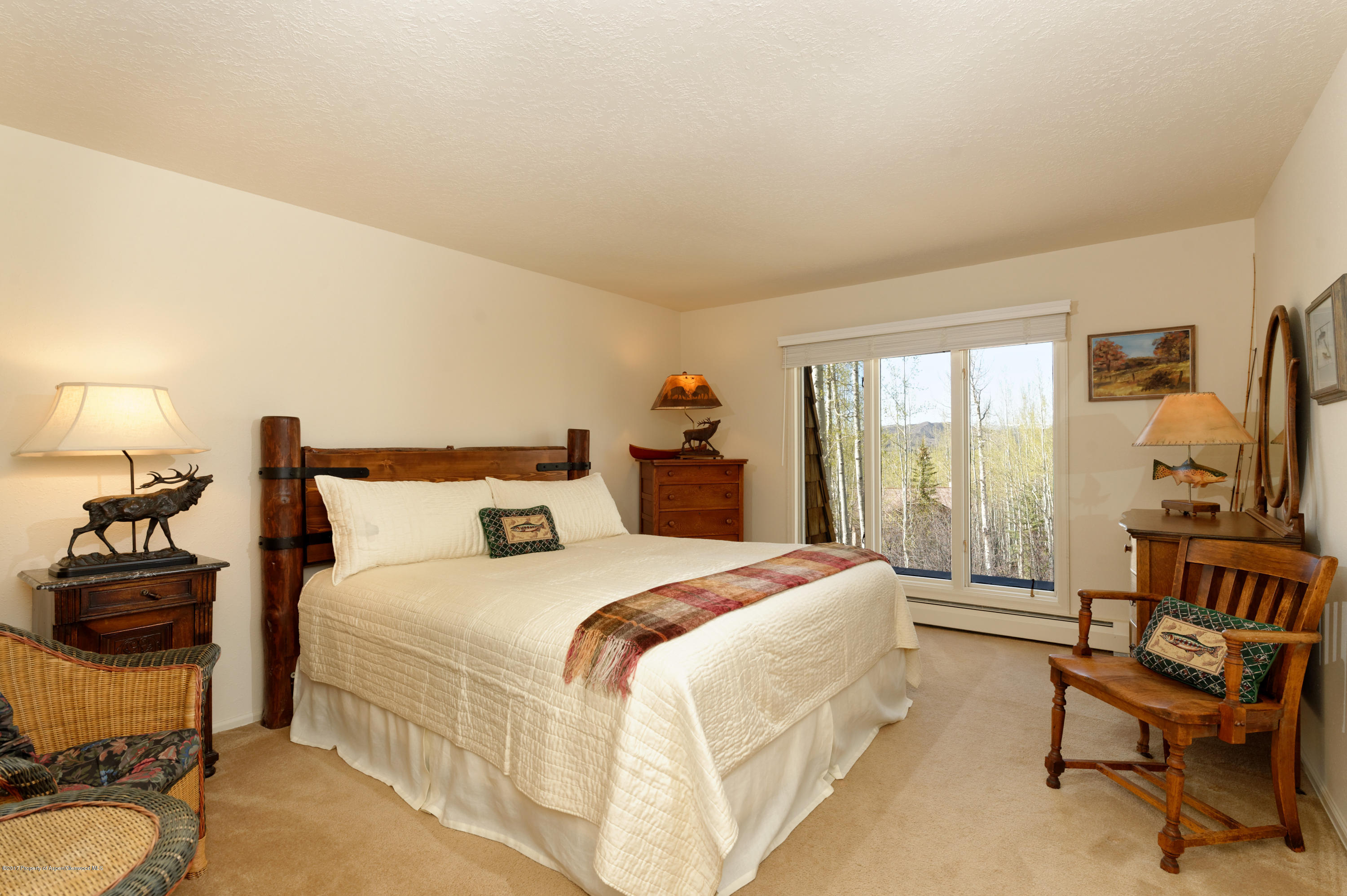 49 Elk Ridge Lane Snowmass Village, CO 81615 - Photo 16 of 24 a bedroom with a bed a large window and chair