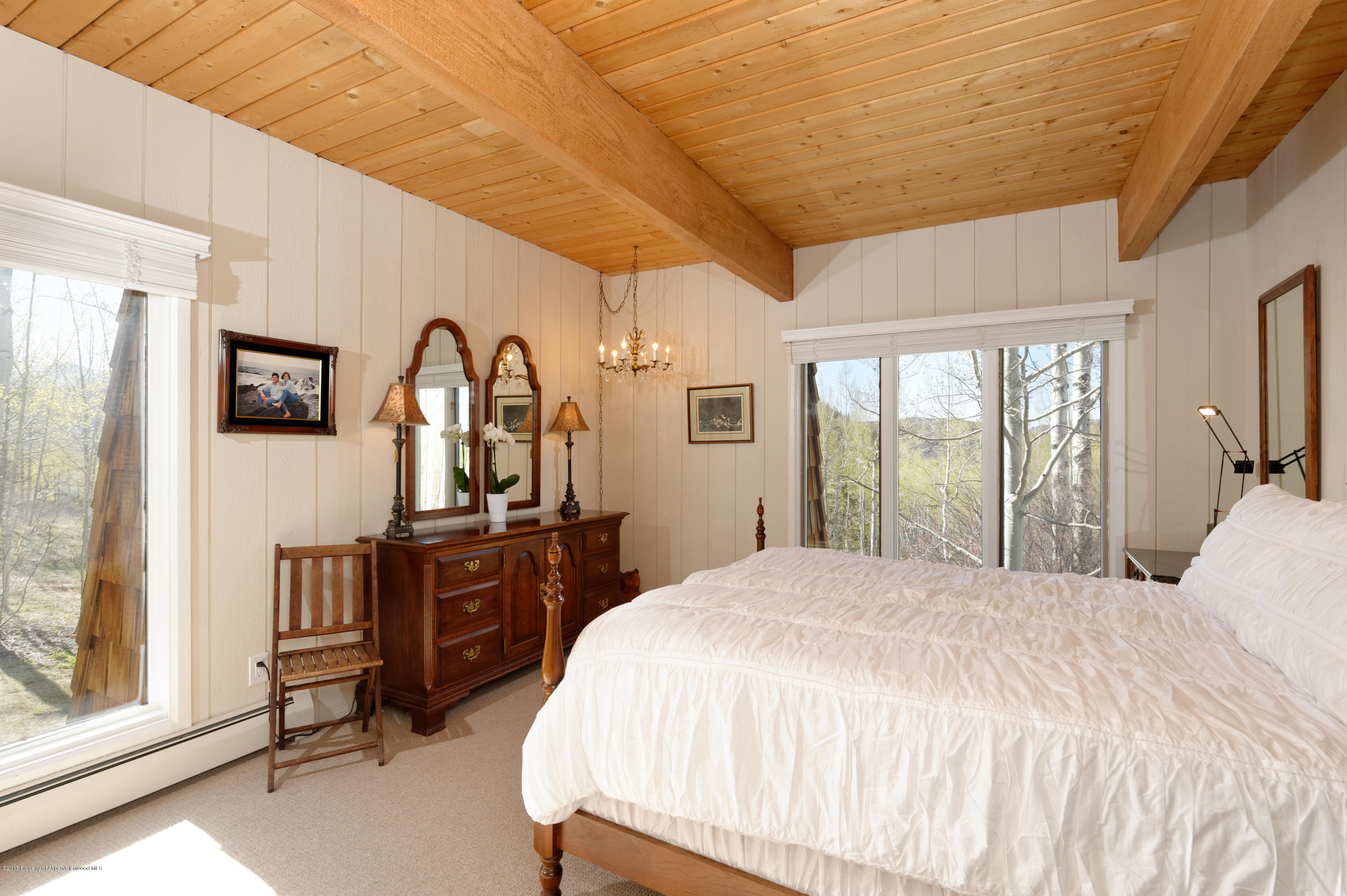 49 Elk Ridge Lane Snowmass Village, CO 81615 - Photo 9 of 24 a bedroom with a large bed a flat tv screen and dresser