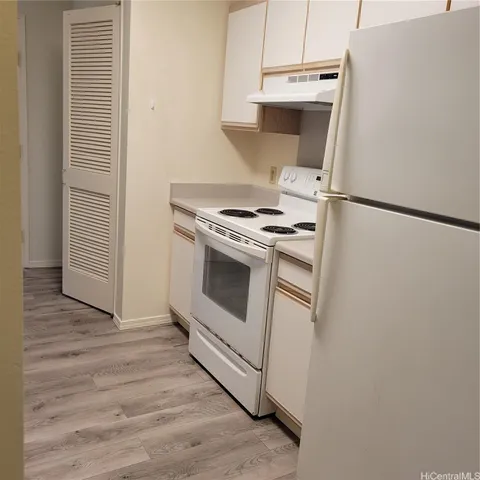 a kitchen with a stove and a white refrigerator