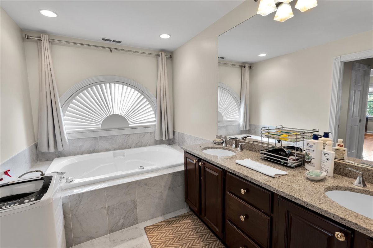 310 North County Line Road Hinsdale, IL 60521 - Photo 19 of 43 a bathroom with a double vanity sink and a bathtub