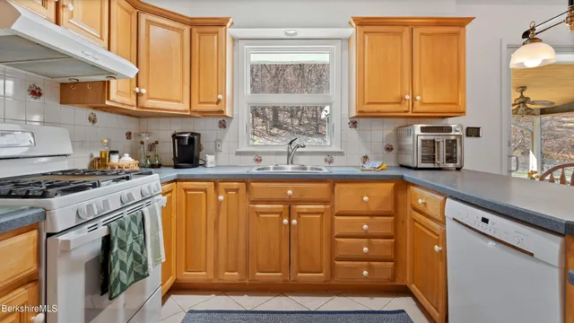 a kitchen with stainless steel appliances granite countertop a sink stove and cabinets