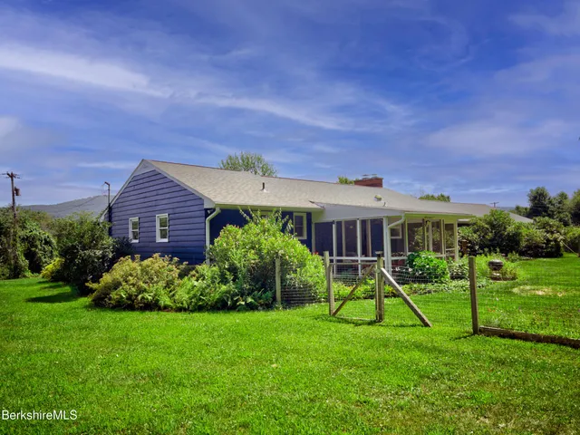 a view of a house with a backyard and a porch