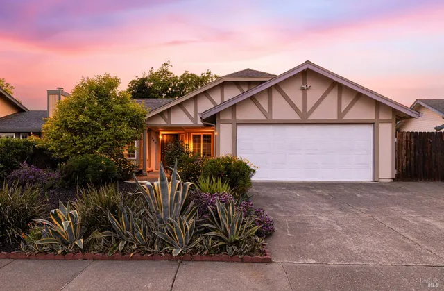 a view of a house with potted plants next to a road