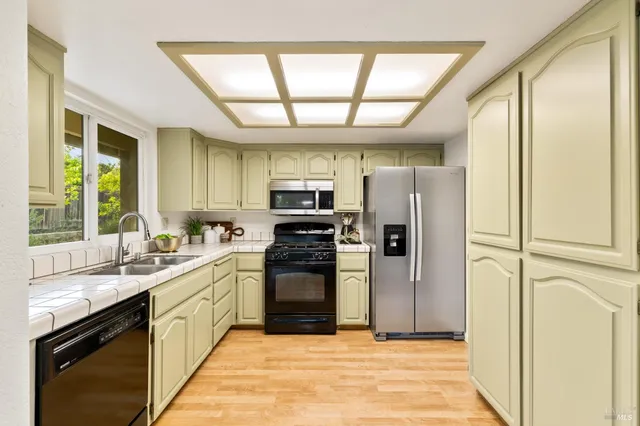 a large kitchen with a large window appliances and cabinets