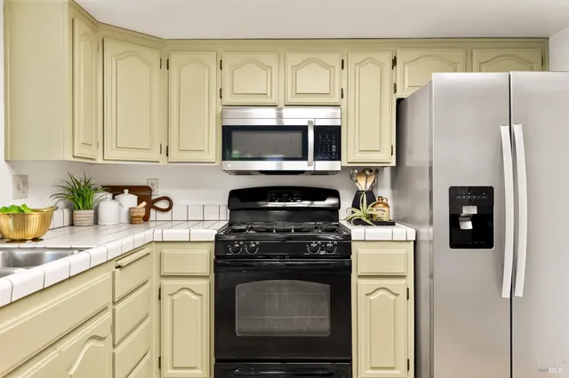 a kitchen with cabinets stainless steel appliances and a sink