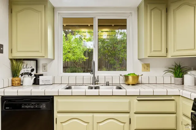 a kitchen with stainless steel appliances granite countertop a sink and a white cabinets