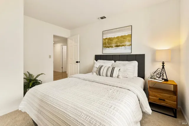 a bedroom with a bed and a lamp on dresser