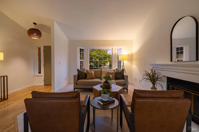 a living room with furniture a fireplace and a large window