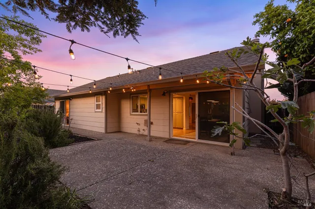 a view of a house with a yard and wooden fence