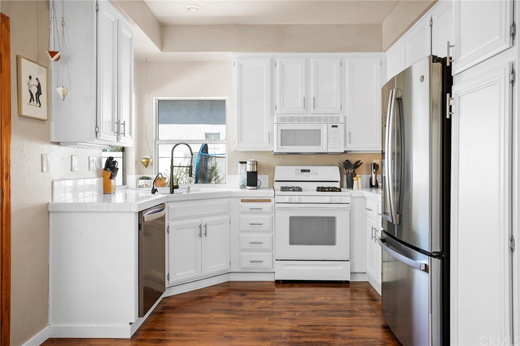 32289 Cercle Beauregard Temecula, CA 92591 - Photo 6 of 45 a kitchen with white cabinets and white appliances