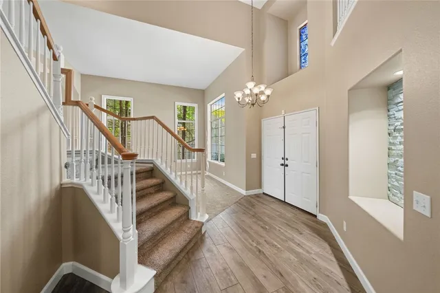 a view of a hallway with wooden floor and staircase
