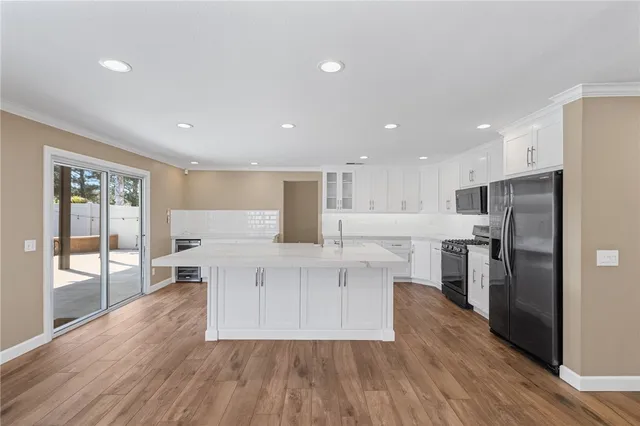 a kitchen with stainless steel appliances a refrigerator and wooden floor