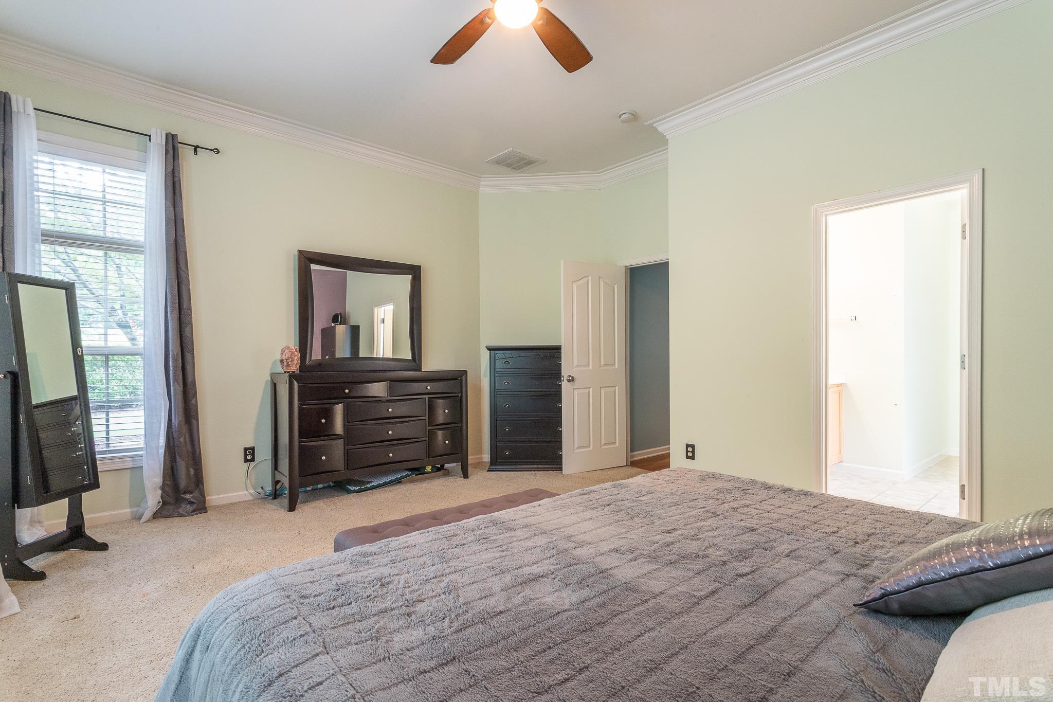 6221 Oconner Street Raleigh, NC 27617 - Photo 21 of 26 a bedroom with a bed and a chandelier