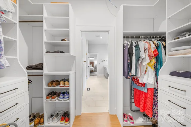 a view of walk in closet with clothes and shoes