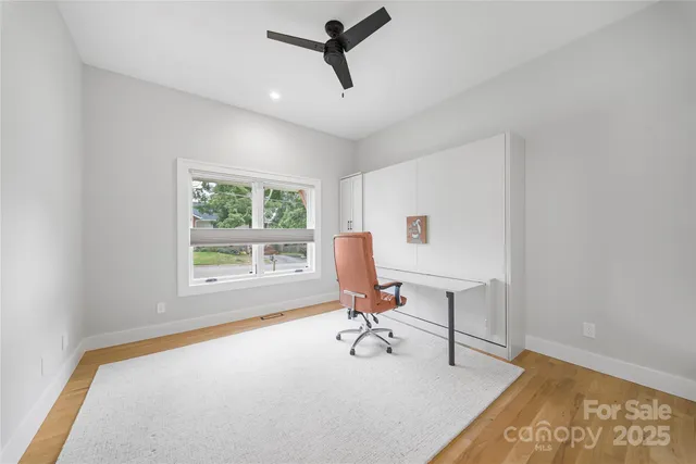 a view of a workspace with furniture and a window