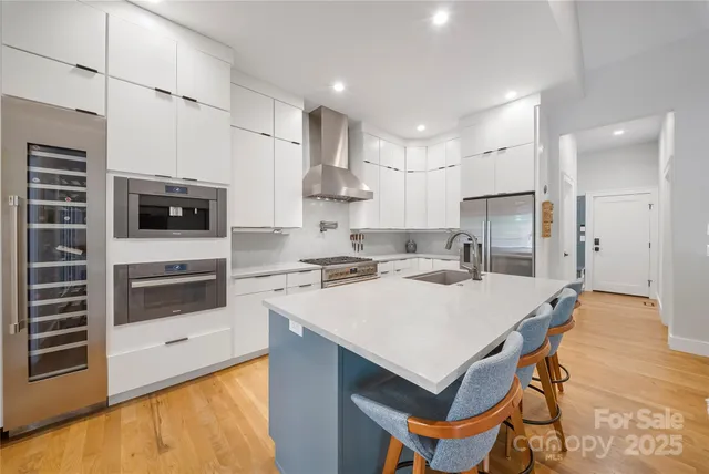 a kitchen with stainless steel appliances a stove a sink and a refrigerator