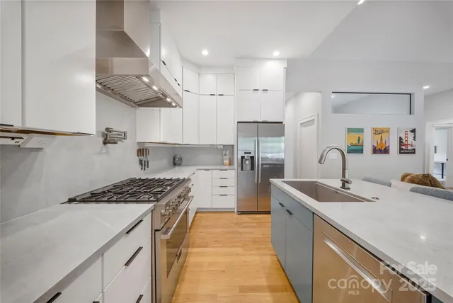 a kitchen with stainless steel appliances granite countertop a sink stove and refrigerator